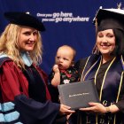 Brittany Ann Josewski and daughter Violet congratulated by WHCL President Dr. Kristin Clark following Thursday's commencement ceremony.